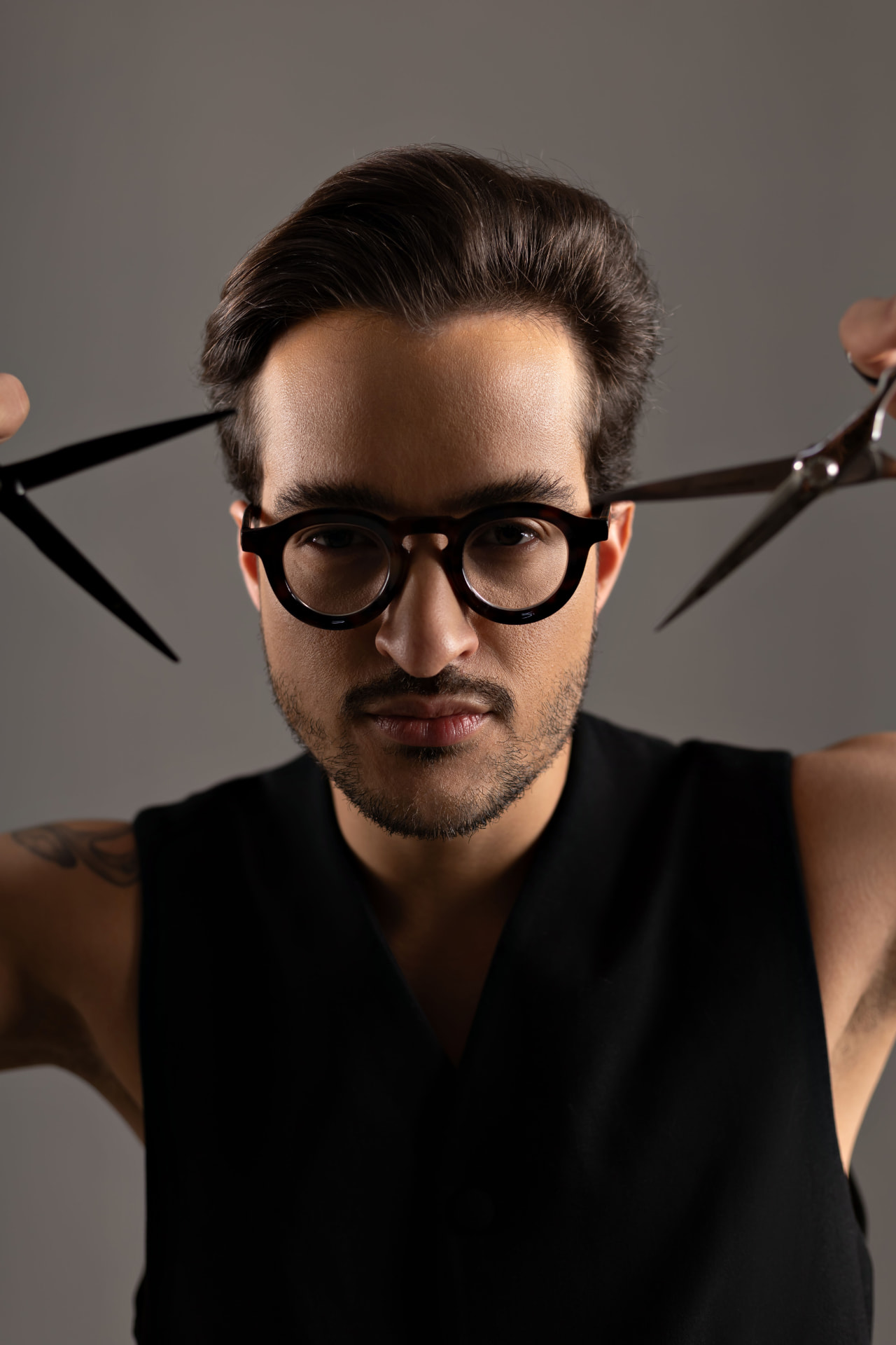 Vini com óculos e tesouras em retrato editorial